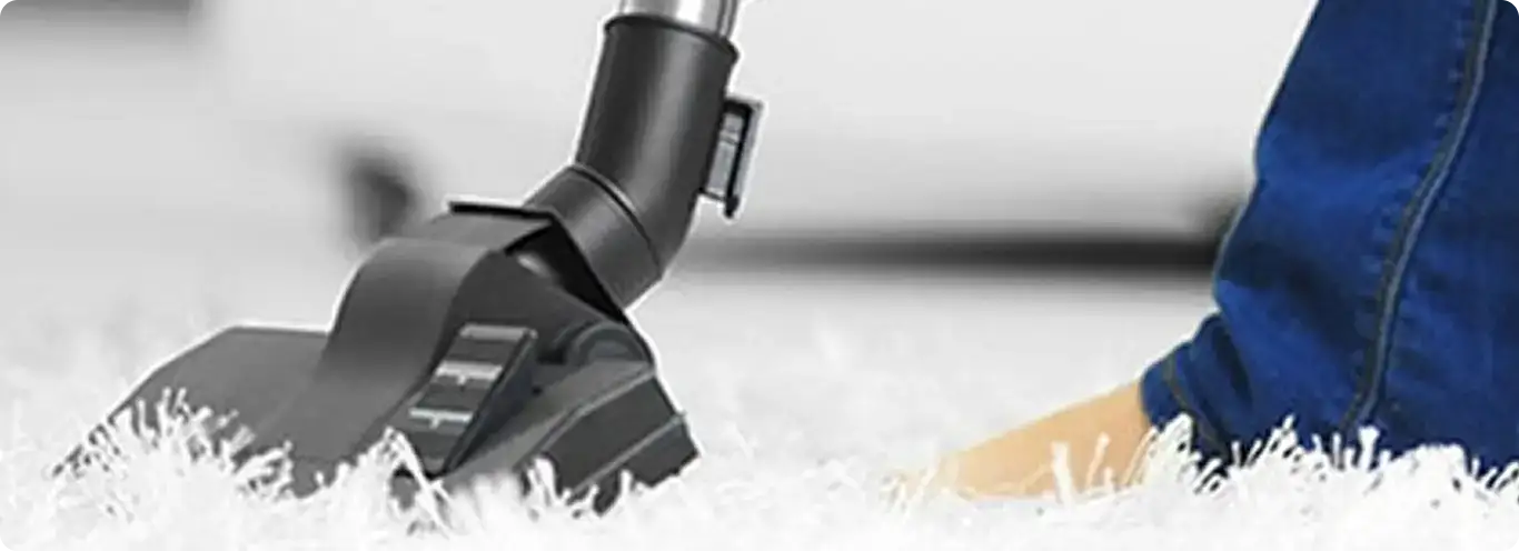 Close-up of a professional vacuuming a white carpet in West Des Moines.